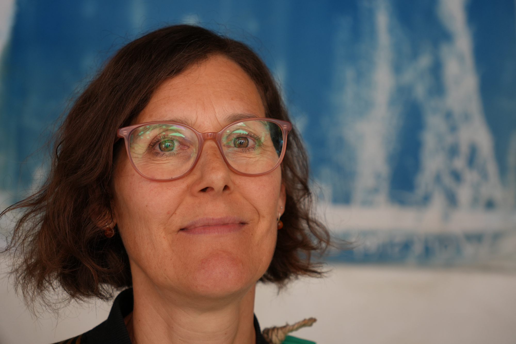 Eine Frau vor einem blauen abstrakten Kunstwerk.